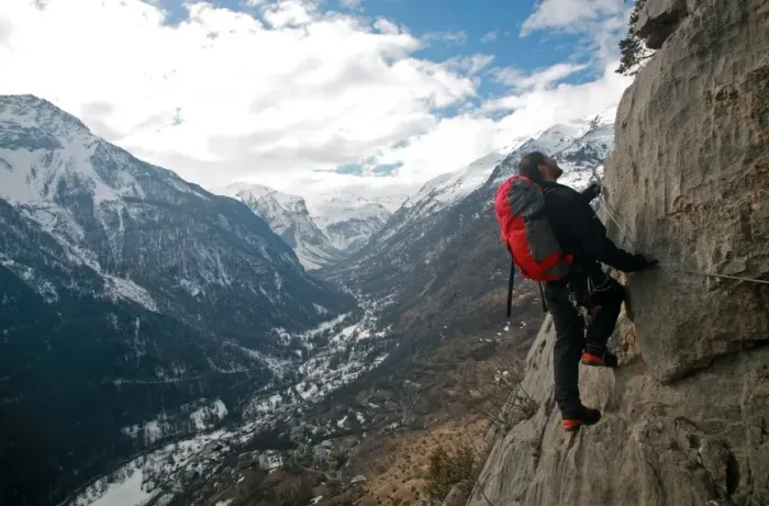 Framed Print : A man on a via ferrata route high above the tiny village of Fressinieres