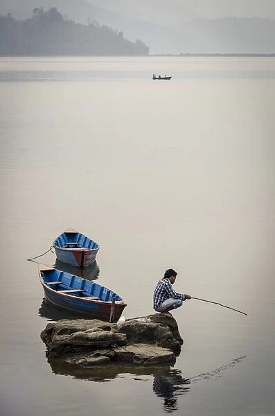 A man fishing on Phewa Tal (Phewa Lake), Pokhara, Nepal, Asia