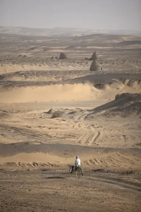 Framed Print : A man on mule-back traverses the desert around Framed Print : A man on mule-back traverses the desert around