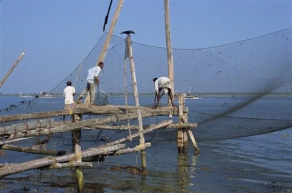 Man operating large Chinese fishing nets at Fort Cochin
