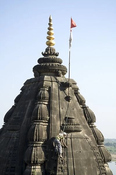 Man picking weeds out of the Shiva Hindu temple on