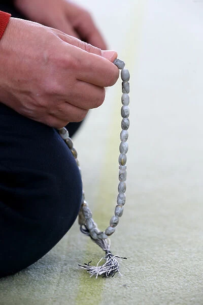 Man praying in a mosque with Tasbih (prayer beads), Bussy-Sainte-Georges, Seine-et-Marne