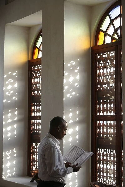 Man reading Koran in a Doha mosque, Doha, Qatar, Middle East