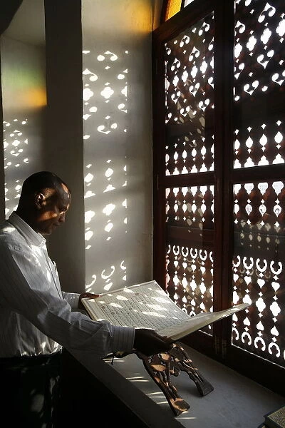 Man reading the Koran in a Doha mosque, Doha, Qatar, Middle East