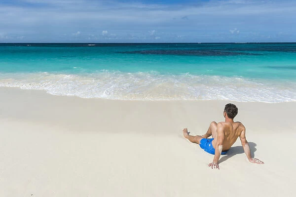 Man relaxing on the world class Shoal Bay East beach, Anguilla, British Oversea territory