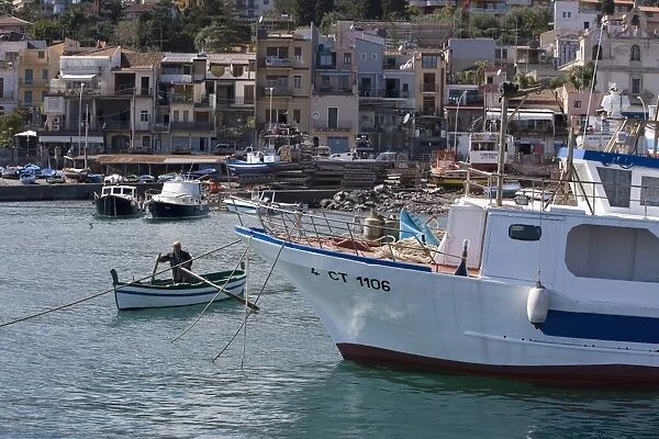 Man rowing a traditional fishing boat in the harbour