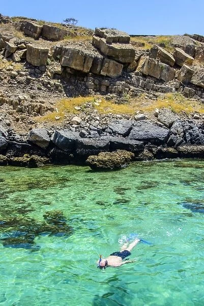 Man snorkelling in the clear waters of Telegraph Island in the Khor ash-sham fjord, Musandam, Oman, Middle East