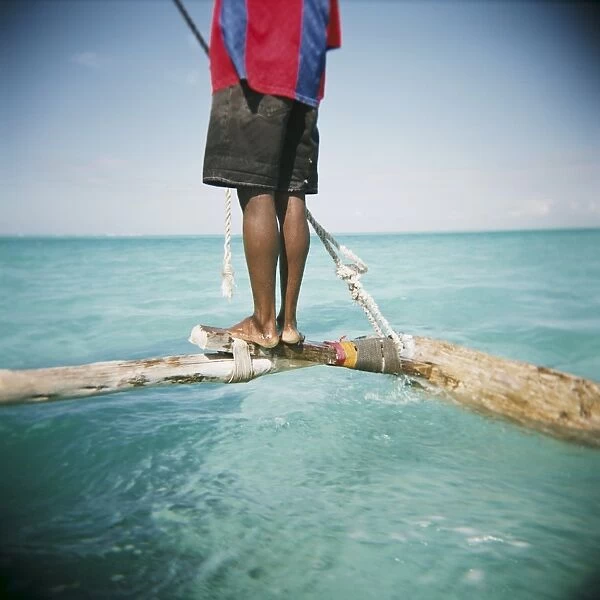 Man standing on outrigger in Indian Ocean, Zanzibar, Tanzania, East Africa, Africa