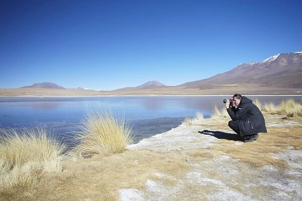 Man taking photos at Laguna Canapa on Altiplano, Potosi Department, Bolivia, South America
