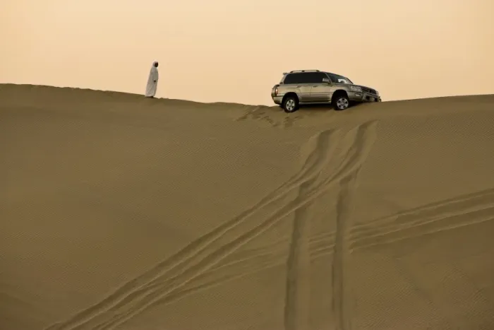 Framed Print : Man in traditional Arab dress looking at 4x4 car stuck on the ridge of a dune during a desert safari near Abu Dhabi, United Arab Emirates Framed Print : Man in traditional Arab dress looking at 4x4 car stuck on the ridge of a dune during a desert safari near Abu Dhabi, United Arab Emirates
