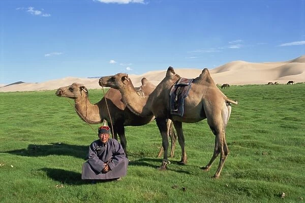Man in traditional clothing with two camels from a camel caravan