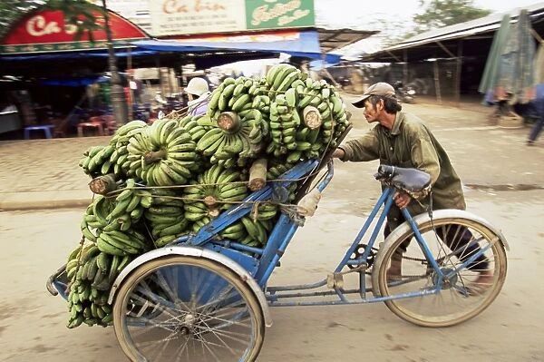 Man transporting bananas on cyclo