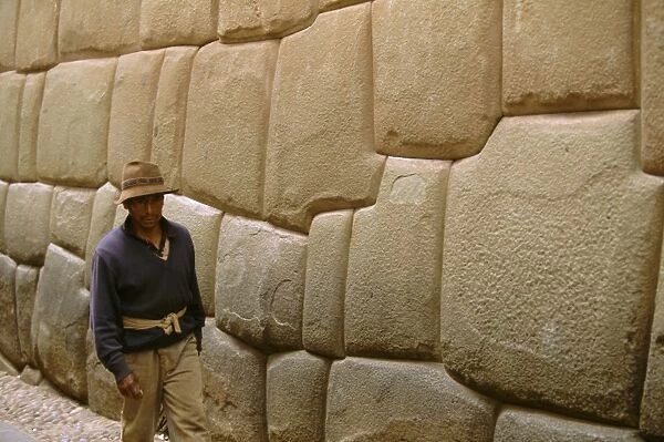 Man walking alongside Inca wall
