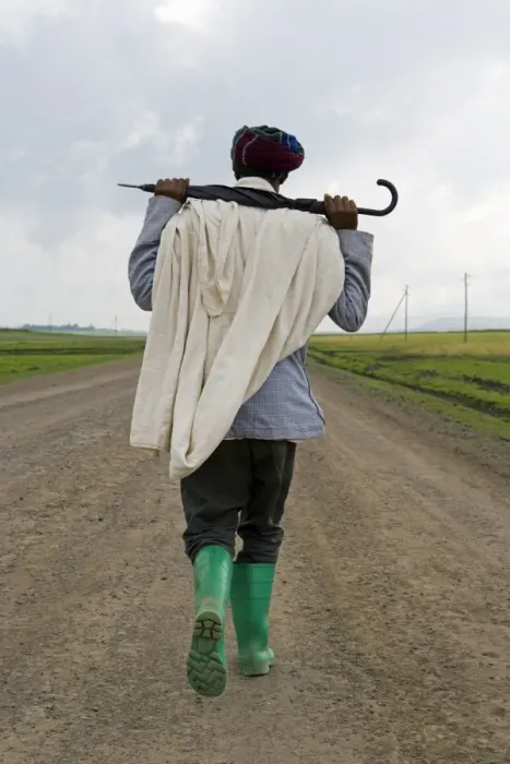 Framed Print : Man walking along the road during the rainy season wearing green boots Framed Print : Man walking along the road during the rainy season wearing green boots