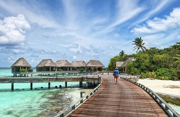 Man walking on a wooden jetty, Baa Atoll, Maldives, Indian Ocean, Asia