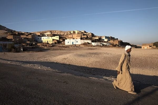 A man walks past a village on the West Bank of Luxor, Egypt, North Africa, Africa