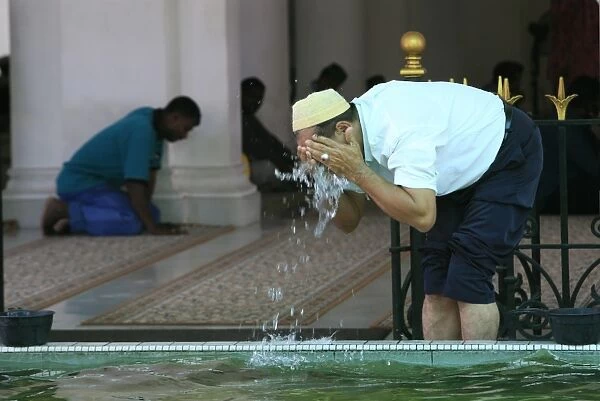 Man washing before prayers, Kapitan Kling Mosque, Penang, Malaysia, Southeast Asia, Asia
