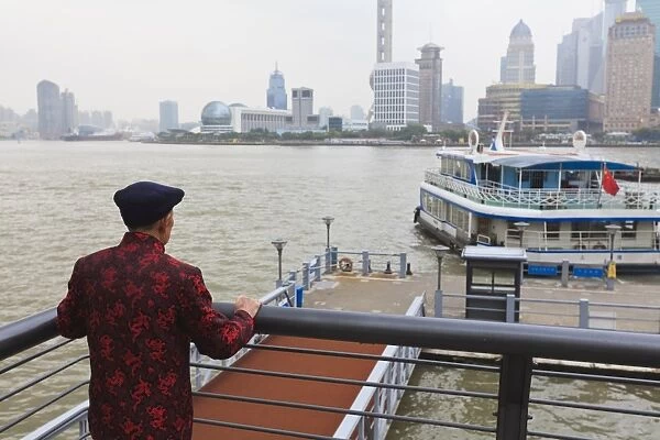 A man watching ferries crossing the Huangpu River, Shanghai, China, Asia