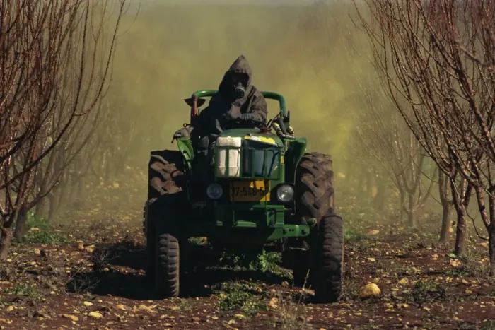 Framed Print : Man wearing protective clothing on a tractor spraying orchards in winter in Upper Galilee Framed Print : Man wearing protective clothing on a tractor spraying orchards in winter in Upper Galilee