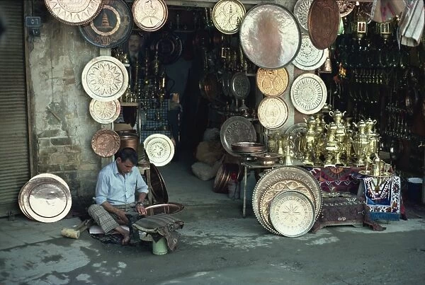 Man working on copper plate outside a copper souk, Baghdad, Iraq, Middle East
