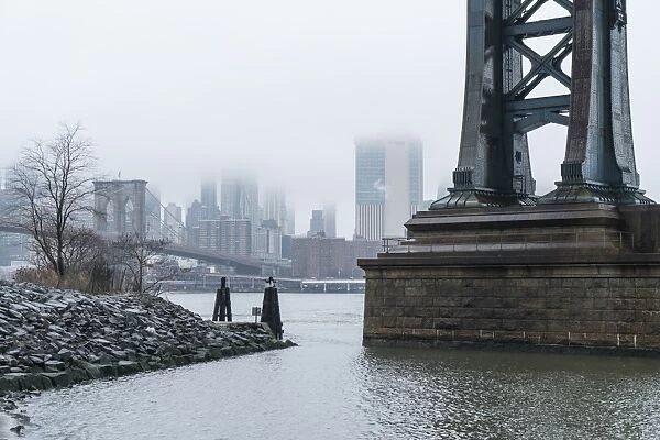 Manhattan Bridge on a cold foggy day, Brooklyn Bridge and skyline beyond, New York City