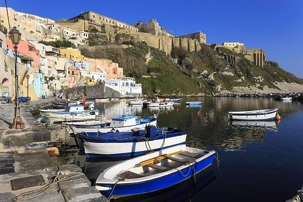 Marina Corricella, pretty fishing village, boats below Terra Murata acropolis fortress