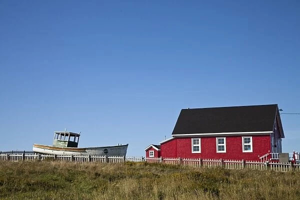 Maritime house painted red with boat on lawn, Iles de la Madeleine (Magdalen Islands)