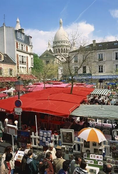 Market stalls and outdoor cafes in the Place du Tertre, with the Sacre Coeur behind