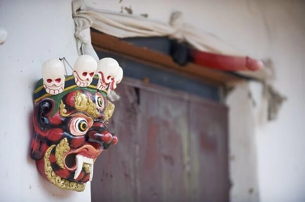 Mask and phallus hanging on a door to protect its occupants, near the temple of the Divine Madman