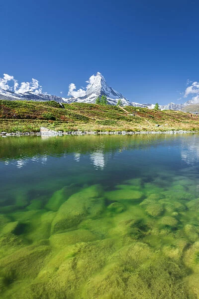 Matterhorn peak covered with snow reflected in the clear water of lake Leisee, Sunnegga