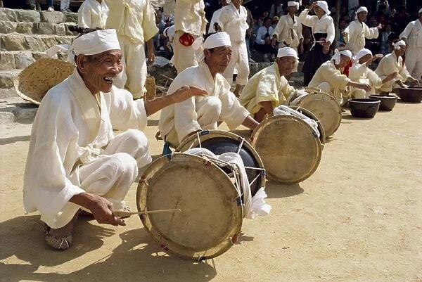 Men beating drums during the traditional farmers dance