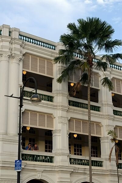 Two men enjoying a drink on balcony of Raffles Hotel