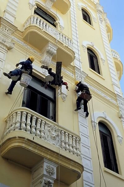 Men painting building without aid of scaffolding, Havana, Cuba, West Indies