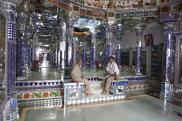 Two men sitting in ornately decorated Jain temple in backstreet, Udaipur