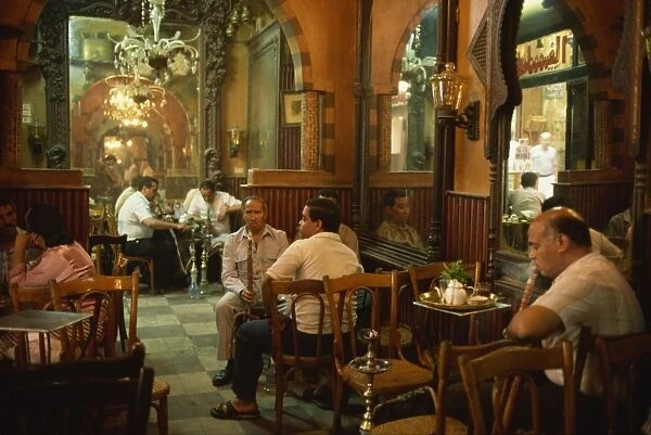 Men smoking hookahs in the interior of the El Fishawy Coffee House in Khan al-Kalili Bazaar in Cairo, Egypt, North