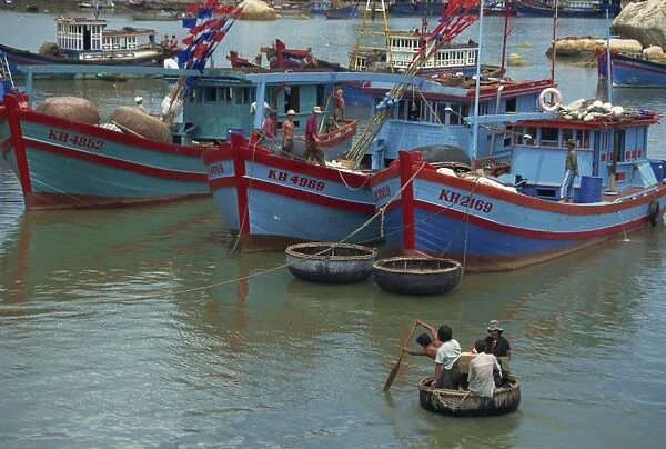 Men in Thung Chai basket boat paddle to boats at Nha Trang in Vietnam