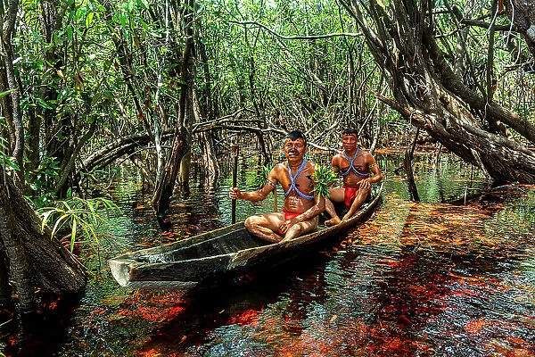 Men from the Yanomami tribe in a canoe, southern Venezuela, South America