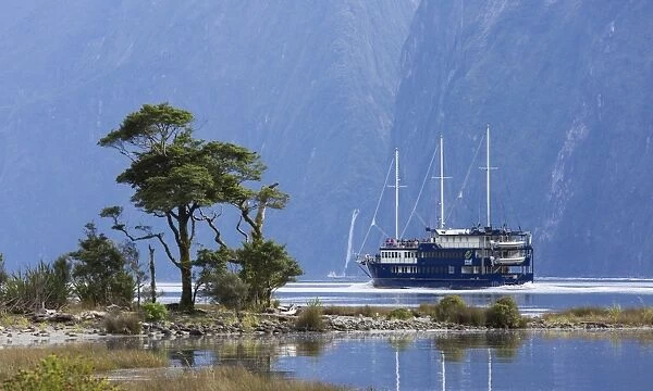 The Milford Mariner dwarfed by steep mountains, Milford Sound, Fiordland National Park