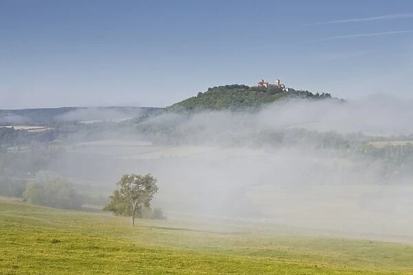 Mist clears away from around the hilltop village of Vezelay in the Yonne area of Burgundy, France, Europe