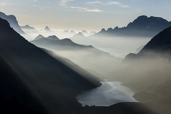 Mist on peaks of Dolomites and Monte Civetta seen from Cima Belvedere at dawn, Val di Fassa
