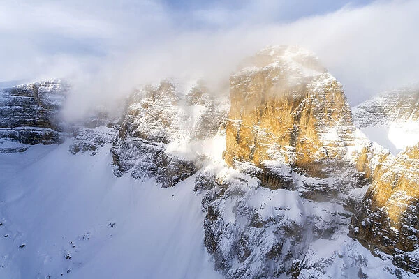 Mist over the rocky peaks of Sella Group during a snowy winter, Gardena Pass, Dolomites