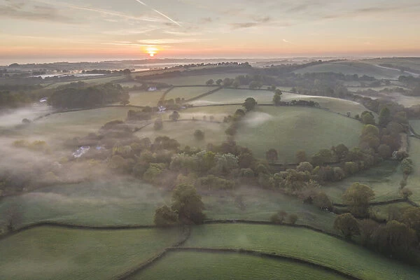 Misty spring sunrise over rolling countryside, South Tawton, Devon, England