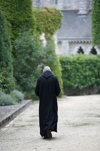 Monk walking in Saint-Pierre de Solesmes Abbey, Solesmes, Sarthe, Pays de la Loire