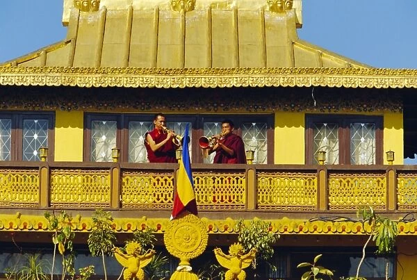Monks blowing Tibetan horns on the roof the Sakyapa gompa