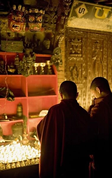 Monks light butter lamps on an auspicious night