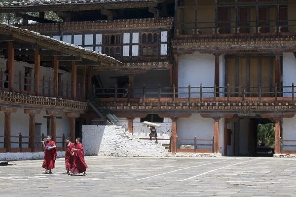 Monks walking in the court of the old Wangdue monastery, Bhutan, Asia