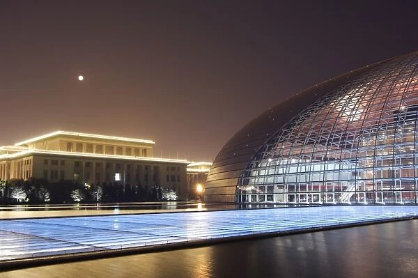Full moon above Soviet style Great Hall of the People contrasts with The National Theatre Opera House, also known as The Egg designed by French architect Paul Andreu and made with glass and titanium opened 2007, Beijing