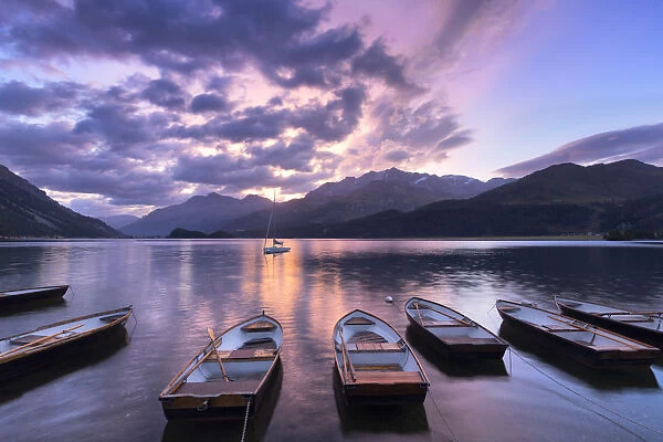 Moored boats in Lake of Sils at sunrise, Maloja Pass, Engadine valley, Graubunden