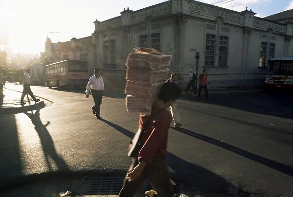 Morning activity on the streets, boy carrying newspapers, San Jose, Costa Rica