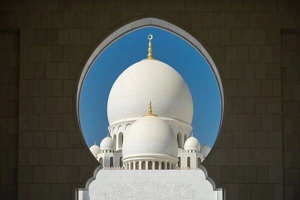 A mosque is framed by an arched passageway in Abu Dhabi, United Arab Emirates, Middle